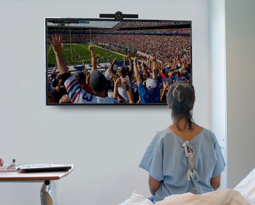 Patient viewing digital signage in a private hospital room.